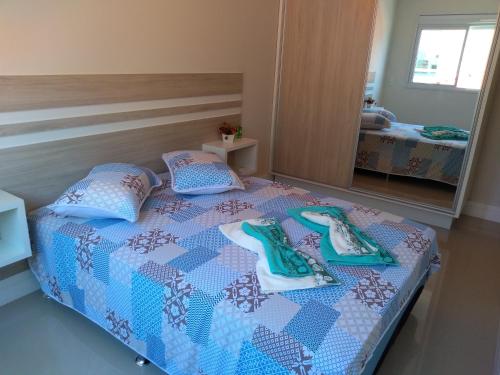 1 dormitorio con 1 cama con toallas en Ap Praia De Palmas, en Governador Celso Ramos