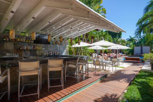 an outdoor bar with chairs and tables and umbrellas at Magic Blue Spa Boutique Hotel Adults Only in Playa del Carmen