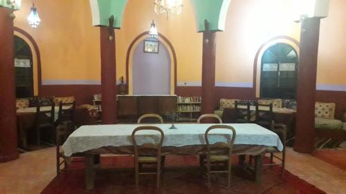a dining room with a table and chairs in it at d'hôte Jnane-Dar Diafa in Tamgrout