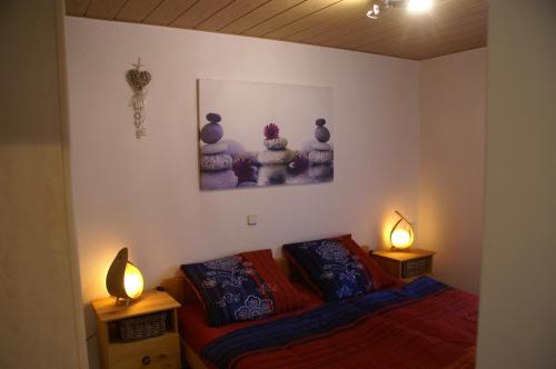 a bedroom with a bed and two lamps on tables at Ferienhaus-4Seasons in Gönnersdorf