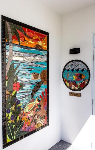 a painting hanging on a wall next to a window at The Beach Pad Puntas in Rincon