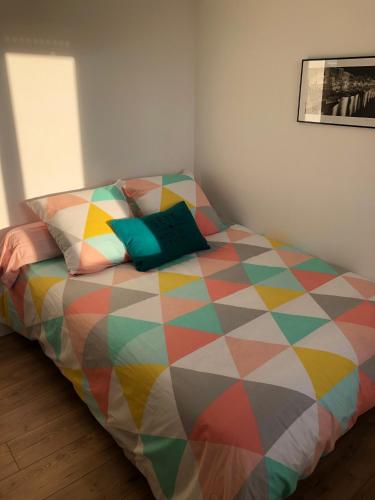 a bed with a colorful comforter in a room at L'Escale Sètoise in Sète
