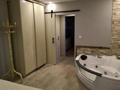 y baño con bañera blanca y lavamanos. en Apartamento Usuaia con jacuzzi, en Lesaka