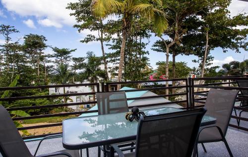a table and chairs on a balcony with trees at The Beach Pad Puntas in Rincon