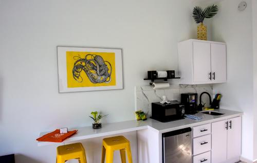 a kitchen with a desk and two yellow stools at The Beach Pad Puntas in Rincon