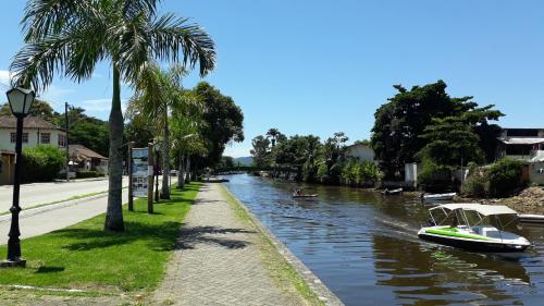 a boat traveling down a river with palm trees at Tropical Contemporary Suites in Paraty