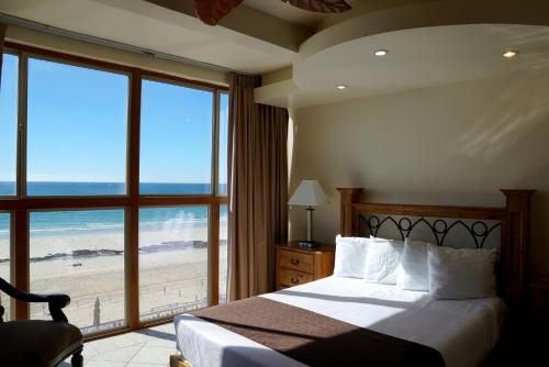 a bedroom with a bed with a view of the beach at Hotel Playa Bonita Resort in Puerto Peñasco