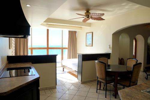 a kitchen with a table, chairs and a refrigerator at Hotel Playa Bonita Resort in Puerto Peñasco