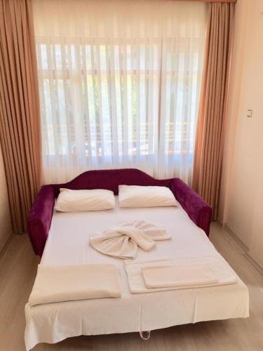 a white bed with a bow on top of it at Üstün Apart in Marmaris