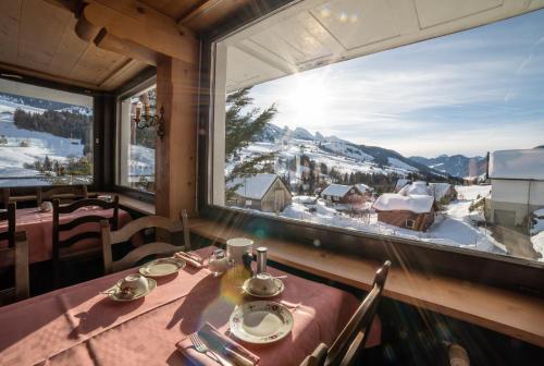 a dining room with a table and a large window at Gasthaus Friedegg in Wildhaus