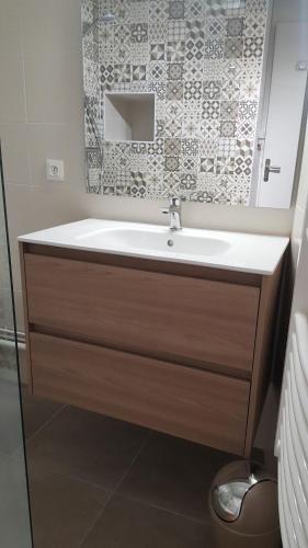 une salle de bain avec un lavabo et un miroir dans l'établissement Gîte 