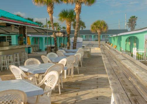 una fila de mesas y sillas en un paseo marítimo en Sea Vista Motel, en New Smyrna Beach
