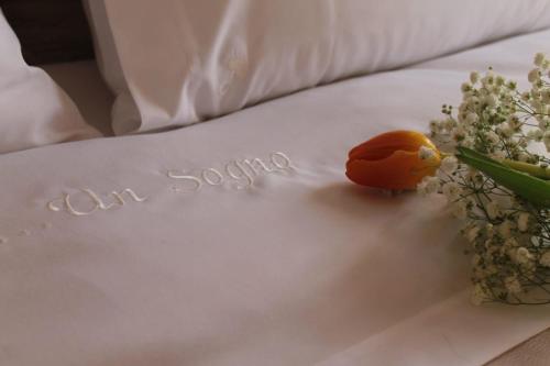 a table with a napkin with a piece of fruit and flowers at Un sogno B&B in Marghera