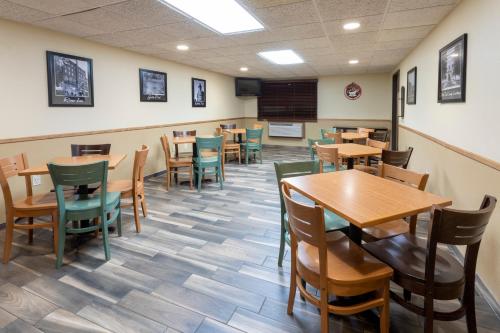 a dining room with wooden tables and chairs at AmericInn by Wyndham Fergus Falls Conference Center in Fergus Falls