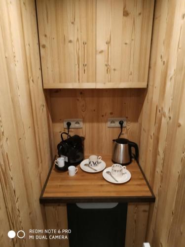 - une petite table en bois avec une bouilloire et des assiettes dans l'établissement Re(s)source, au Chambon-sur-Lignon