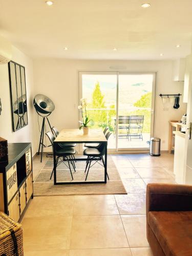 un salon avec une table et des chaises et une cuisine dans l'établissement Villa des Rubens, à Grésy-sur-Aix