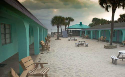 un gruppo di tavoli e panche accanto a un edificio di Sea Vista Motel a New Smyrna Beach