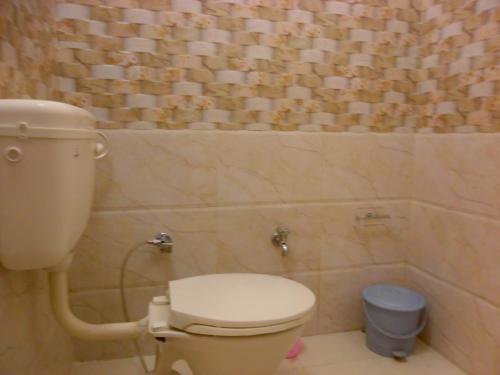 a bathroom with a toilet and a trash can at Hotel Sidhartha in Agra