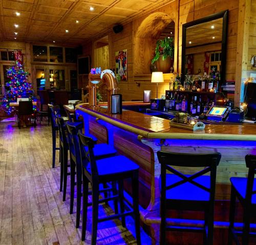 un bar avec un arbre de Noël dans un restaurant dans l'établissement Guest House du Grand Paradis - On Piste, à Champéry