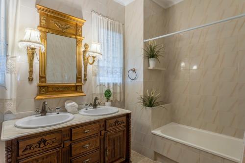 a bathroom with a tub and a sink and a tub and a mirror at Casa Ludima in Fuentes de Andalucía