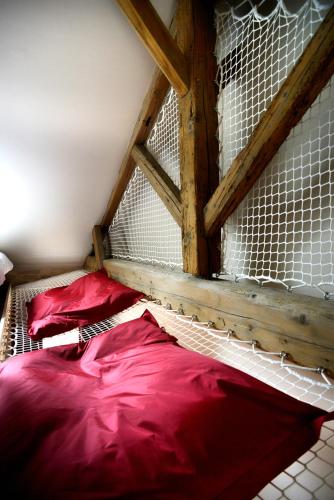 a bunk bed with red sheets and a net at Aux Terrasses in Tournus