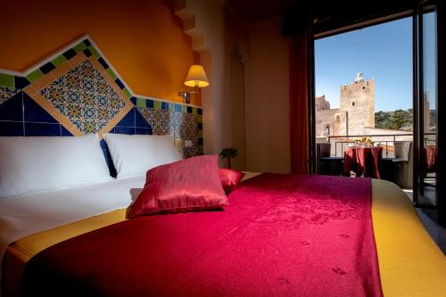 una camera da letto con un grande letto con una grande finestra di Hotel Riva Del Sole a San Vito lo Capo