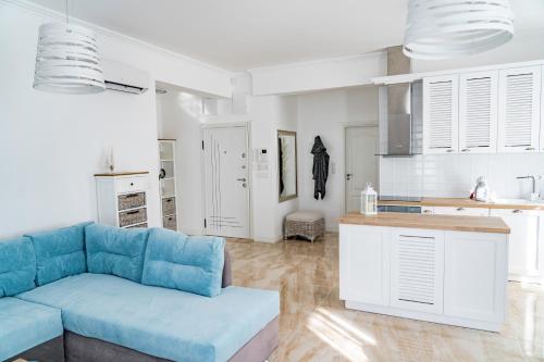 a living room with a blue couch and a kitchen at KApartments in Varna City