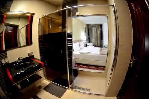 a bathroom with a sink and a bed in a mirror at Hotel New Star in Skopje