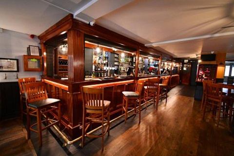 a bar with wooden chairs and a bar counter at Rose and Crown Hotel in Carmarthen