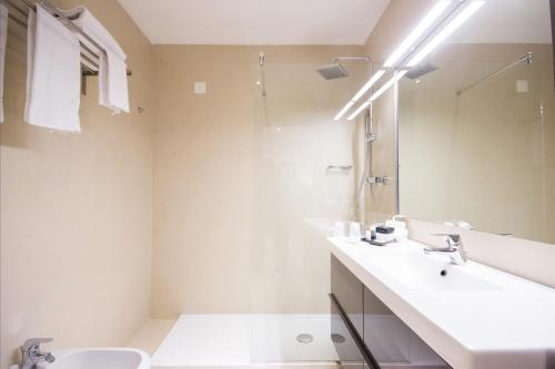 a white bathroom with a sink and a shower at Best Western Modena District in Campogalliano