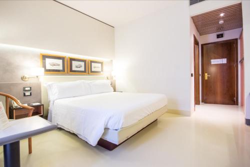 a bedroom with a large white bed and a wooden door at Best Western Modena District in Campogalliano