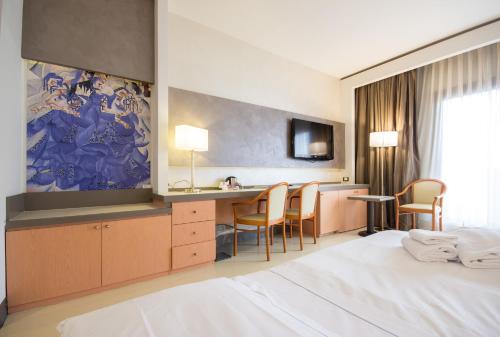 a hotel room with a bed and a table and chairs at Best Western Modena District in Campogalliano