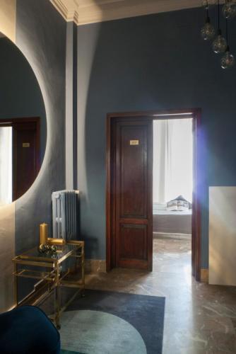 a room with a door and a table and a window at Relais Stibbert Florence in Florence