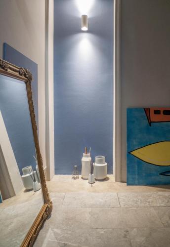 a mirror in a room with a painting on the wall at Relais Stibbert Florence in Florence