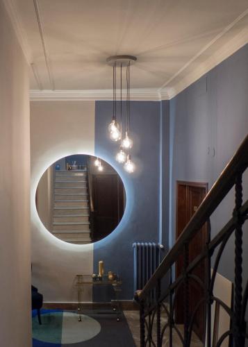 a hallway with a round mirror and blue walls at Relais Stibbert Florence in Florence