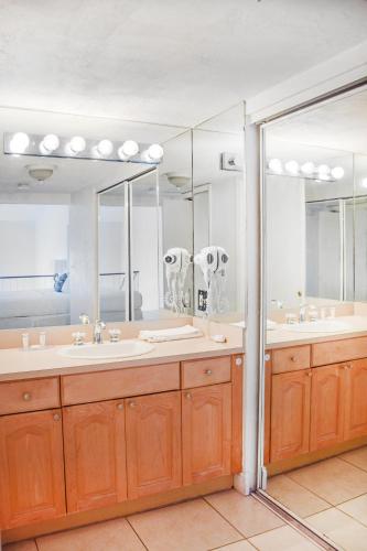 a bathroom with two sinks and a large mirror at Coral Reef at Key Biscayne in Miami
