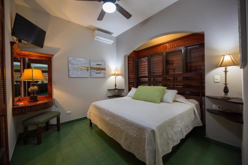 a bedroom with a bed and a desk and a television at Club del Mar Oceanfront in Jacó