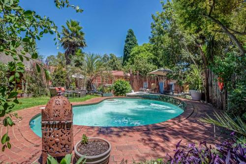 a swimming pool in a yard with a fence at Sitatunga Guest Lodge in Johannesburg