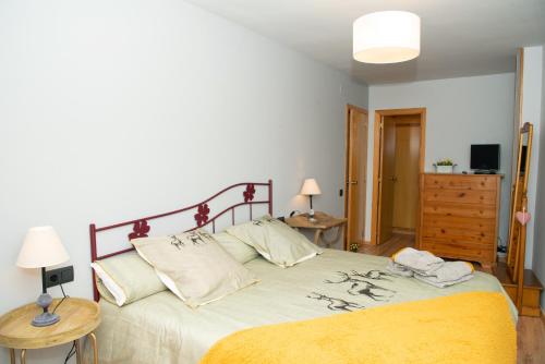 a bedroom with a bed and two tables and a dresser at Apartamento CA L'ANTON con Parking in Rialp