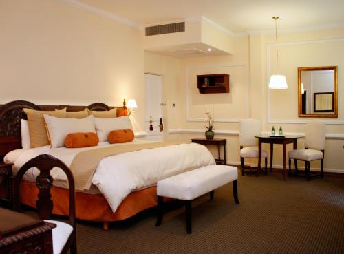 a bedroom with a large bed with white pillows at Hotel Geneve CD de Mexico in Mexico City