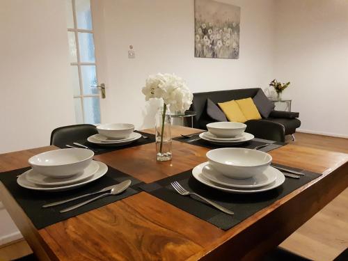 a table with plates and silverware on top of it at Milton House - Entire 3Bed House FREE WIFI & 4 FREE PARKING Spaces Serviced Accommodation Newcastle UK in Newcastle upon Tyne