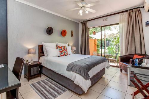 um quarto com uma cama e uma grande janela em Sitatunga Guest Lodge em Joanesburgo