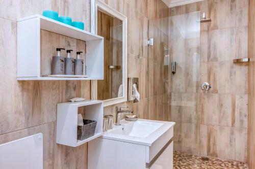 ein Badezimmer mit einem weißen Waschbecken und einer Dusche in der Unterkunft Sitatunga Guest Lodge in Johannesburg