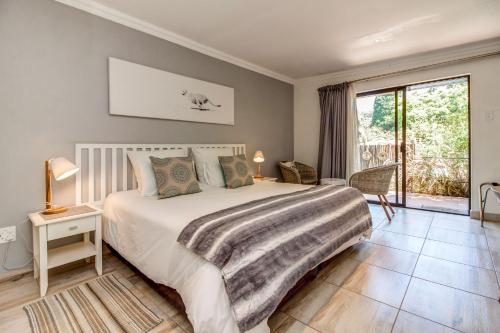 
a bedroom with a large bed and a large window at Sitatunga Guest Lodge in Johannesburg
