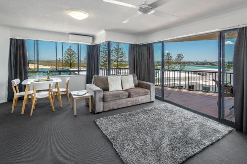a living room filled with furniture and a large window at Belaire Place in Caloundra