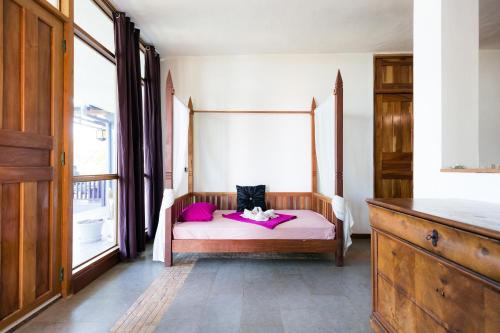 a bedroom with a bed with pink sheets and a window at Punta Duarte Garden Inn in Los Duarte