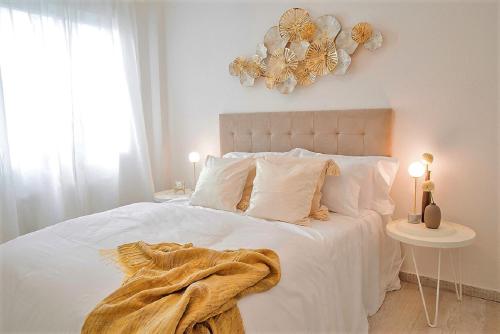 a bedroom with a white bed with a blanket on it at City Valencia Beach 360 in Valencia