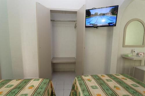 a room with two beds and a flat screen tv at Dorados Conventions & Resort in Oaxtepec
