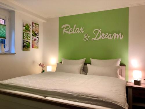 a bedroom with a bed with a green wall at Apartment Casa del Monte in Sinsheim