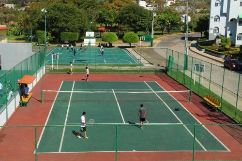 a group of people playing tennis on a tennis court at Dorados Conventions & Resort in Oaxtepec